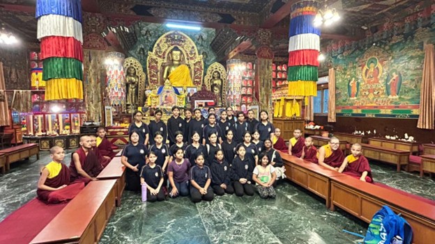 Vantage Hall Girls' School students with Buddhist monks inside a monastery in Dehradun.