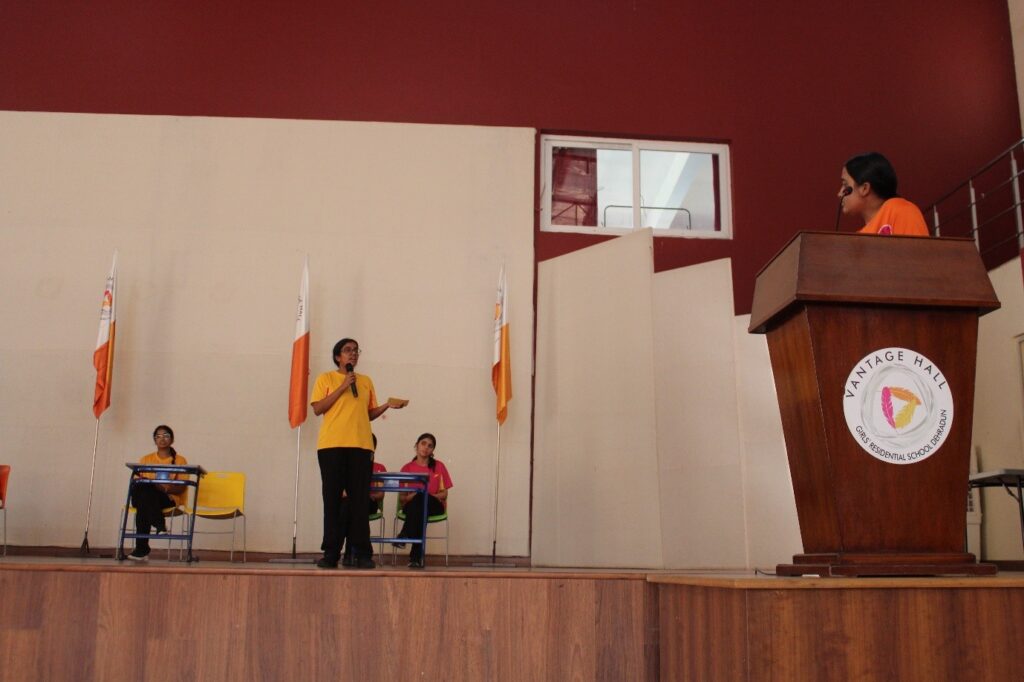 Student orators speaking at the podium during the Inter-House English Debate Competition at Vantage Hall - best girls boarding school in Dehradun